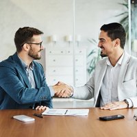 iStock-1444802210_Business_Handshake_Geschäftsmann_Büro_Meeting_Vereinbarung